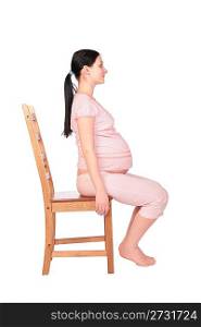 Pregnant girl sits on chair sideview
