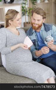 pregnant happy couple with baby accessories
