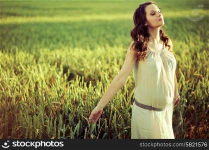 Pregnant lady walking on the corn field
