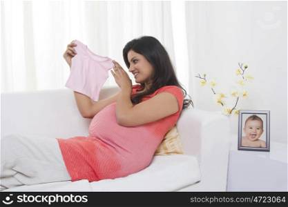 Pregnant mother holding baby shirt