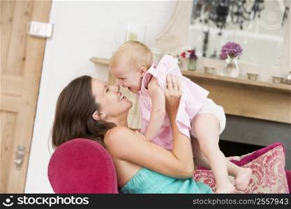 Pregnant mother in living room holding daughter and laughing