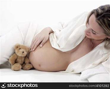 pregnant with bear in bed on a white background