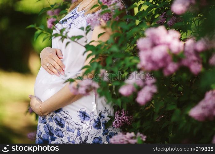 pregnant woman against blossoming tree in spring. Young pregnant woman against blossoming tree in spring