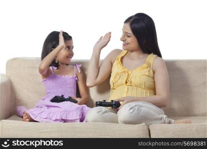 Pregnant woman and her daughter playing video game