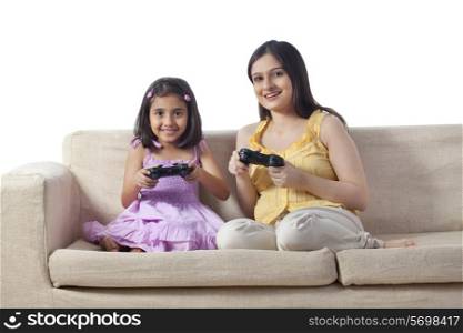 Pregnant woman and her daughter playing video game