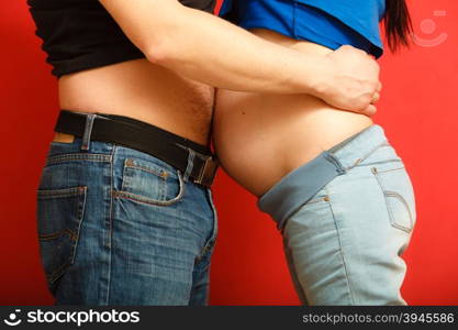 Pregnant woman and her husband. Mom and dad touch each other with their bellies, side view