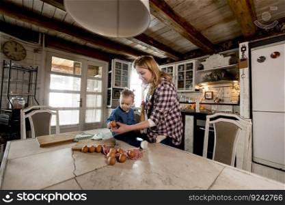 Pregnant woman and little daughter in the rustic kitchen preparing meal