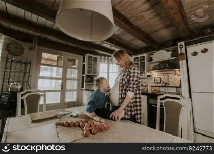 Pregnant woman and little daughter preparing pasta in the rustic kitchen