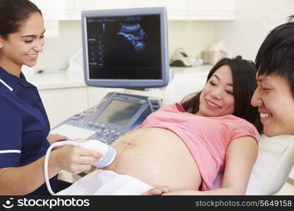 Pregnant Woman And Partner Having 4D Ultrasound Scan