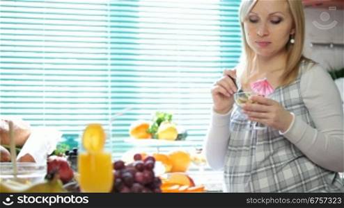 pregnant woman at breakfast in the kitchen