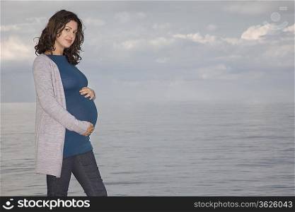 Pregnant woman at ocean, portrait