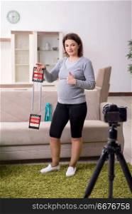 Pregnant woman blogger doing physical exercises