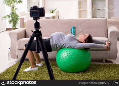 Pregnant woman blogger doing physical exercises 