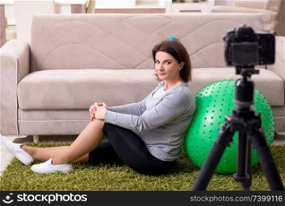 Pregnant woman blogger doing physical exercises 
