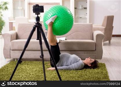 Pregnant woman blogger doing physical exercises 