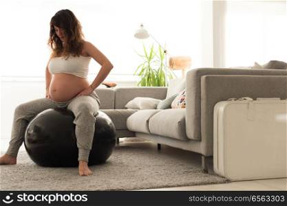 Pregnant woman doing relax exercises with a fitball . Pregnant woman doing relax exercises with a fitness pilates ball at home