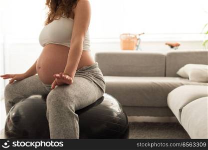 Pregnant woman doing relax exercises with a fitball . Pregnant woman doing relax exercises with a fitness pilates ball at home
