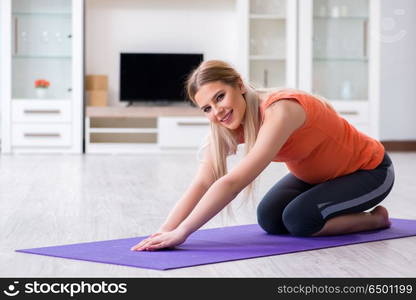 Pregnant woman doing sport exercise at home