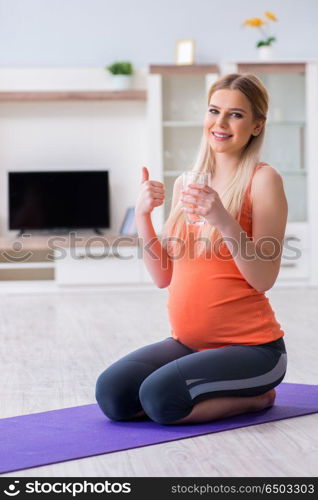 Pregnant woman doing sport exercise at home