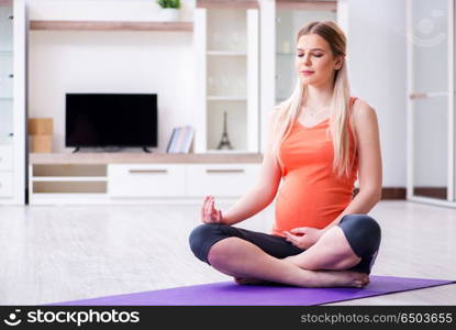 Pregnant woman doing sport exercise at home