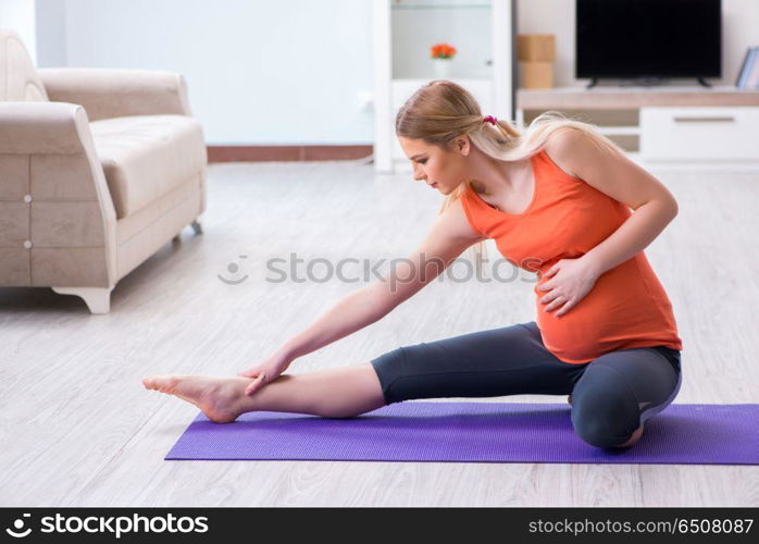 Pregnant woman doing sport exercise at home