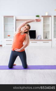 Pregnant woman doing sport exercise at home