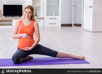 Pregnant woman doing sport exercise at home