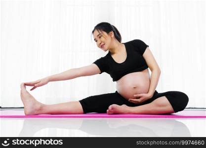 pregnant woman doing yoga exercise in the living room at home