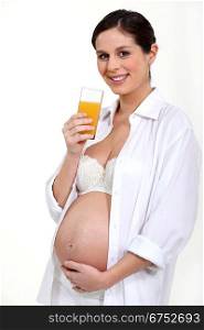 Pregnant woman drinking a glass of juice