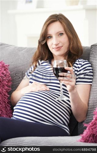 Pregnant Woman Drinking Red Wine At Home