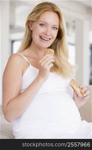 Pregnant woman eating bread and smiling