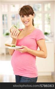 Pregnant woman eating sandwich