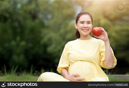 Pregnant woman eating strawberry resting outdoor