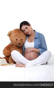 Pregnant woman embracing a teddy bear