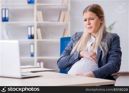Pregnant woman employee in the office