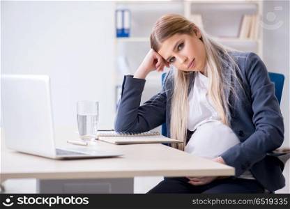Pregnant woman employee in the office