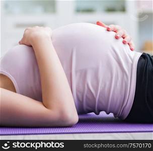 Pregnant woman exercising in anticipation of child birth. The pregnant woman exercising in anticipation of child birth