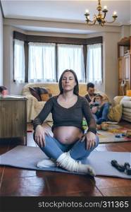Pregnant woman exercising in the living room of her house. Pregnant woman exercising in the living room