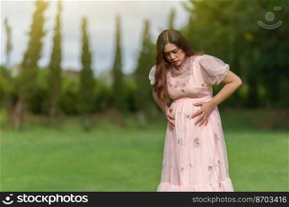 pregnant woman has a stomachache in the park