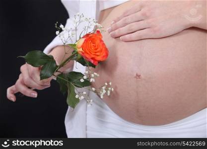 Pregnant woman holding a rose
