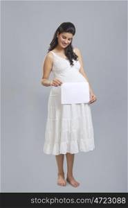 Pregnant woman holding a white board