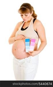 Pregnant woman holding color paint samples and blowing kiss her belly isolated on white&#xA;