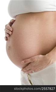 Pregnant woman holding exposed belly