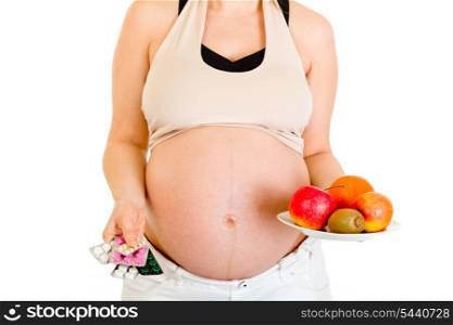 Pregnant woman holding pills and fruits isolated on white. Close-up.&#xA;