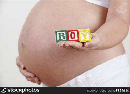 Pregnant Woman Holding Wooden Blocks Spelling Boy