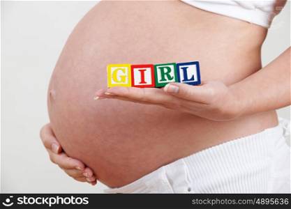 Pregnant Woman Holding Wooden Blocks Spelling Girl