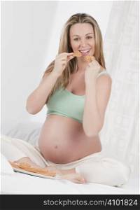 Pregnant woman in bed eating