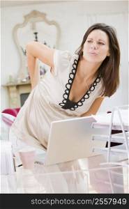 Pregnant woman in home office with a sore back