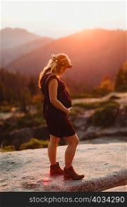 Pregnant woman in mountains touching stomach, Sequoia national park, California, USA