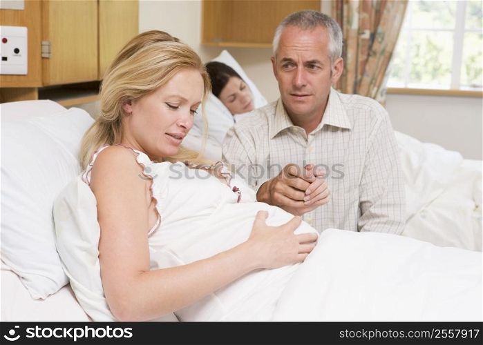Pregnant woman in pain with husband in hospital